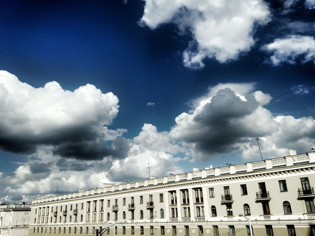Historic Building Under Dramatic Sky with White Clouds
