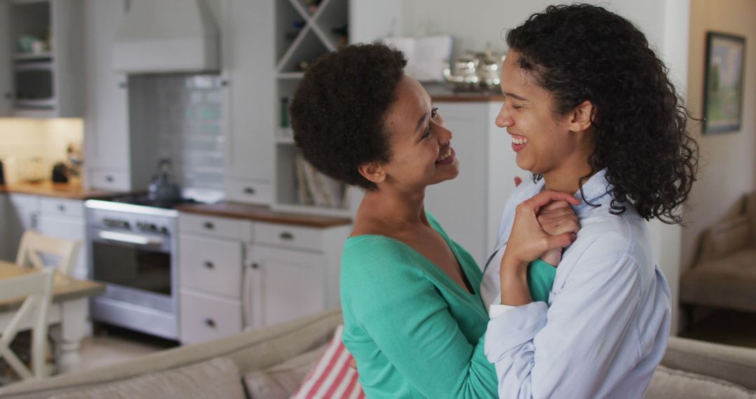 Romantic biracial lesbian couple dancing in sitting room - Free Images, Stock Photos and Pictures on Pikwizard.com