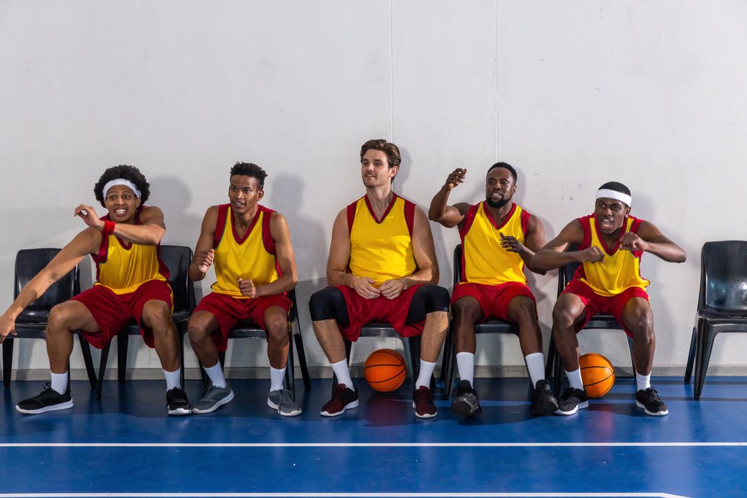 Diverse Male Basketball Team Reacting on Sideline with Balls