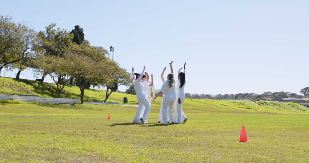 Diverse Female Athletes Celebrating Team Unity on Grassy Field