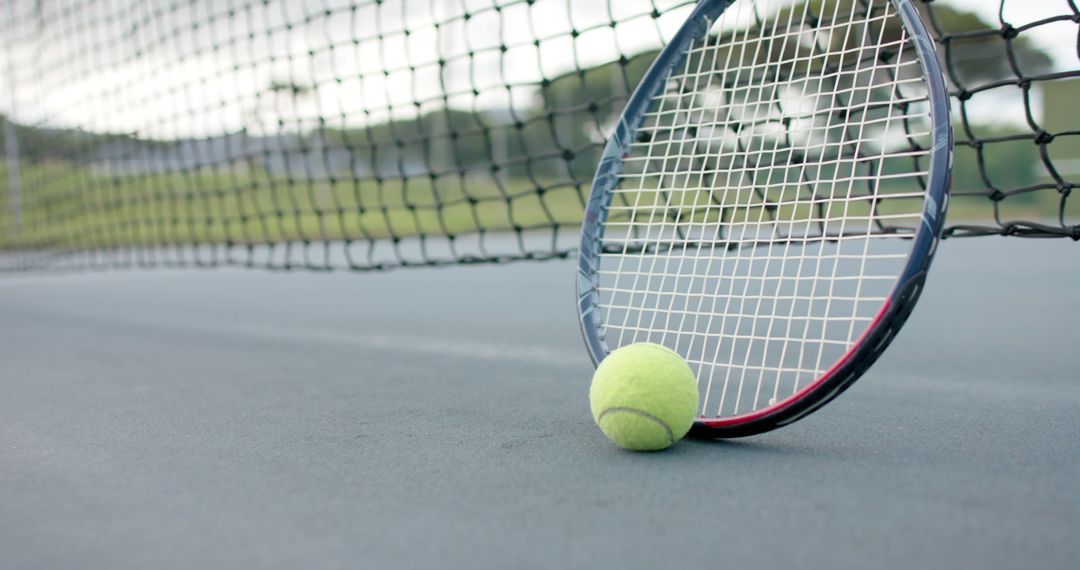 Tennis Racket and Ball Resting on Court by the Net - Free Images, Stock Photos and Pictures on Pikwizard.com