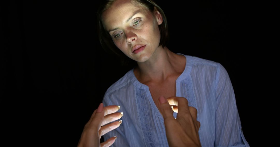 Pensive Woman in Blue Blouse Under Dramatic Lighting - Free Images, Stock Photos and Pictures on Pikwizard.com