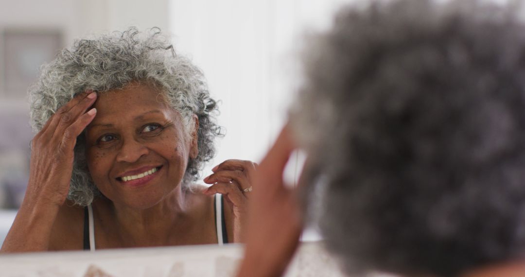 Senior Woman Smiling and Admiring Herself in Mirror - Free Images, Stock Photos and Pictures on Pikwizard.com