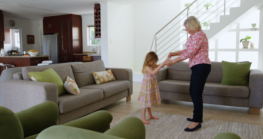 Grandmother Dancing with Granddaughter in Modern Living Room - Free Images, Stock Photos and Pictures on Pikwizard.com