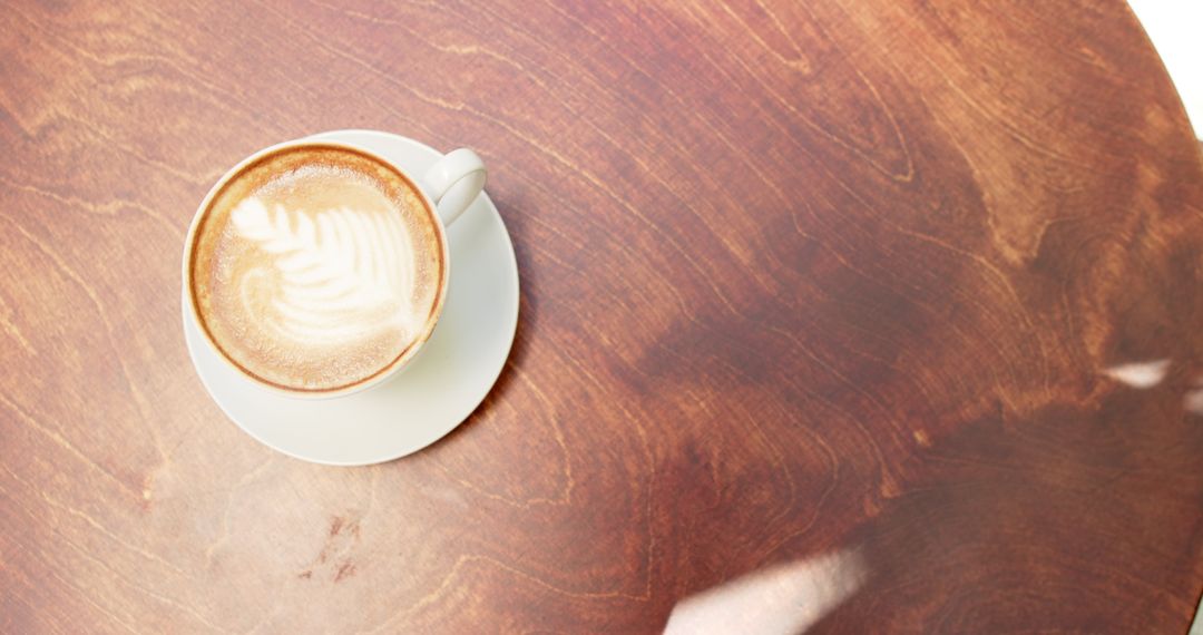Latte Art on Wooden Table in Sunlit Cafe with Copy Space