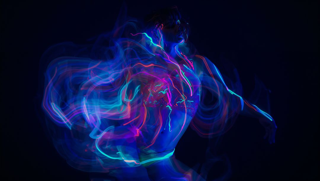 Dancing Performer in Dark Studio with Vibrant Neon LED Light Trails