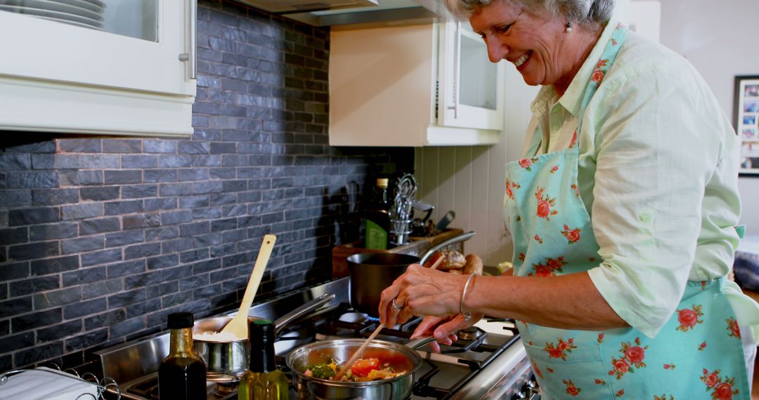 Senior Woman Cooking Delicious Dinner in Modern Kitchen - Free Images, Stock Photos and Pictures on Pikwizard.com