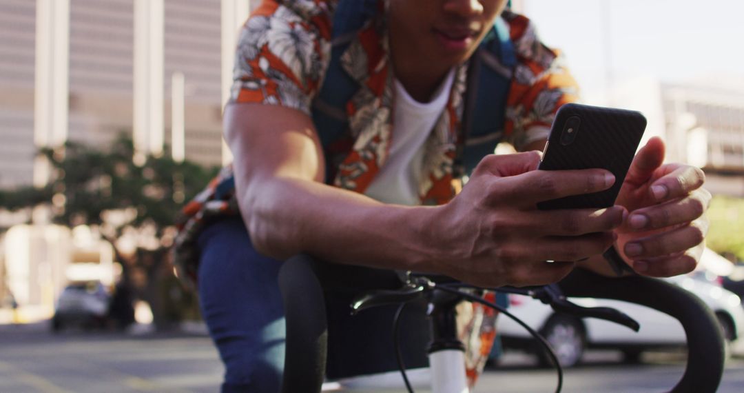 Young man using smartphone while riding bicycle in city - Free Images, Stock Photos and Pictures on Pikwizard.com