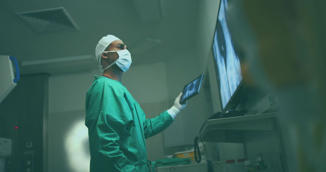 Surgeon in Green Scrubs Analyzing Medical Scans with Tablet