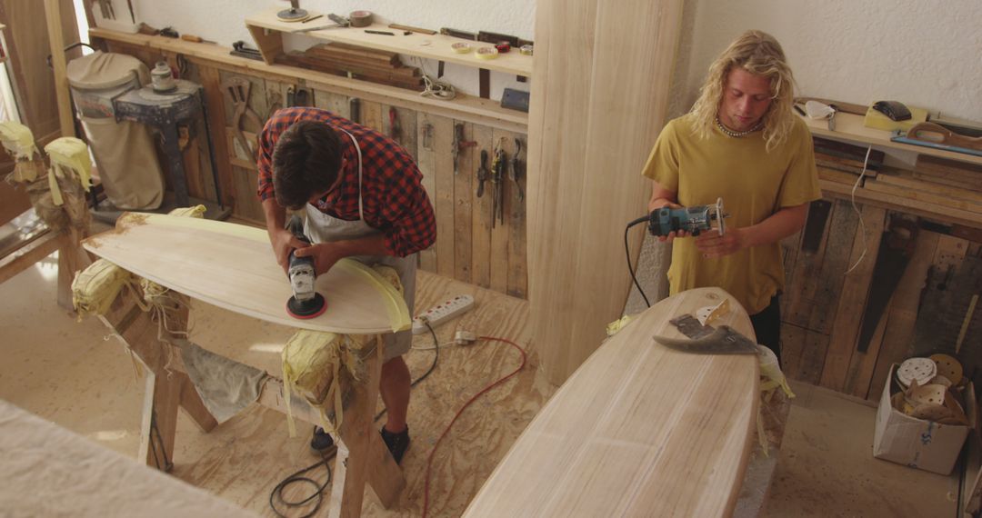 Surfboard craftsmen sanding and shaping in workshop - Free Images, Stock Photos and Pictures on Pikwizard.com