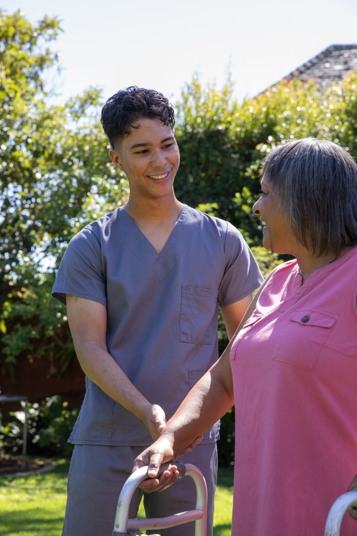 Caregiver Holding Hands with Senior in Serene Outdoor Setting