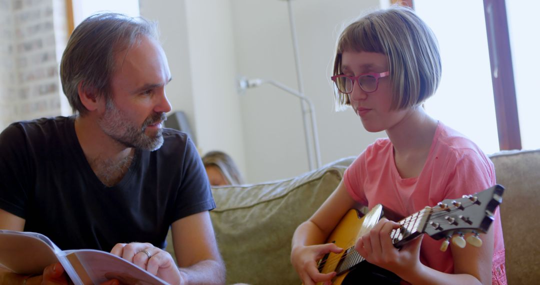 Father and Daughter Playing Guitar Together At Home - Free Images, Stock Photos and Pictures on Pikwizard.com