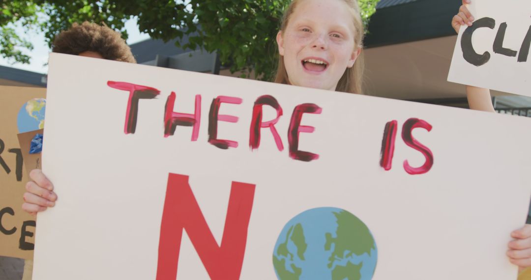 Young Activist Holding Climate Change Protest Sign Outdoors - Free Images, Stock Photos and Pictures on Pikwizard.com