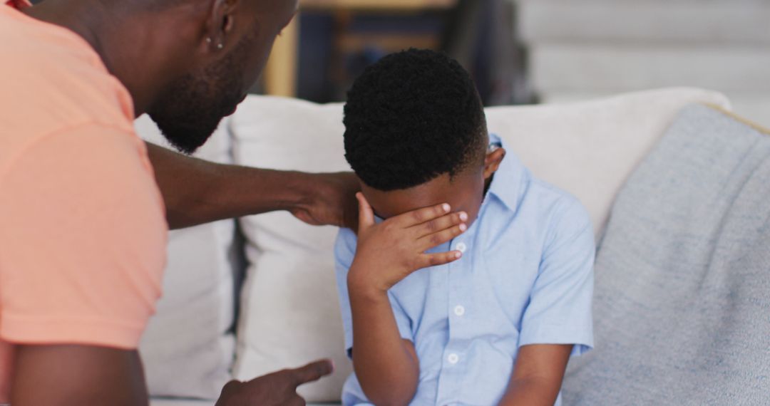 Father comforting sad child covering face at home - Free Images, Stock Photos and Pictures on Pikwizard.com