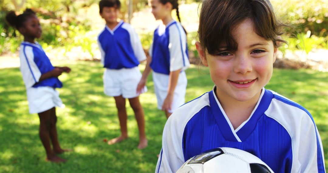 Smiling Girl Holding Soccer Ball with Teammates on Summer Day - Free Images, Stock Photos and Pictures on Pikwizard.com