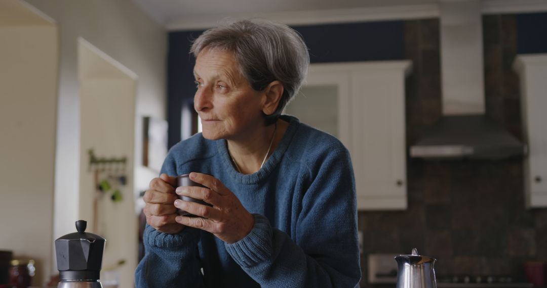 Senior Woman Drinking Coffee Thoughtfully in Kitchen - Free Images, Stock Photos and Pictures on Pikwizard.com