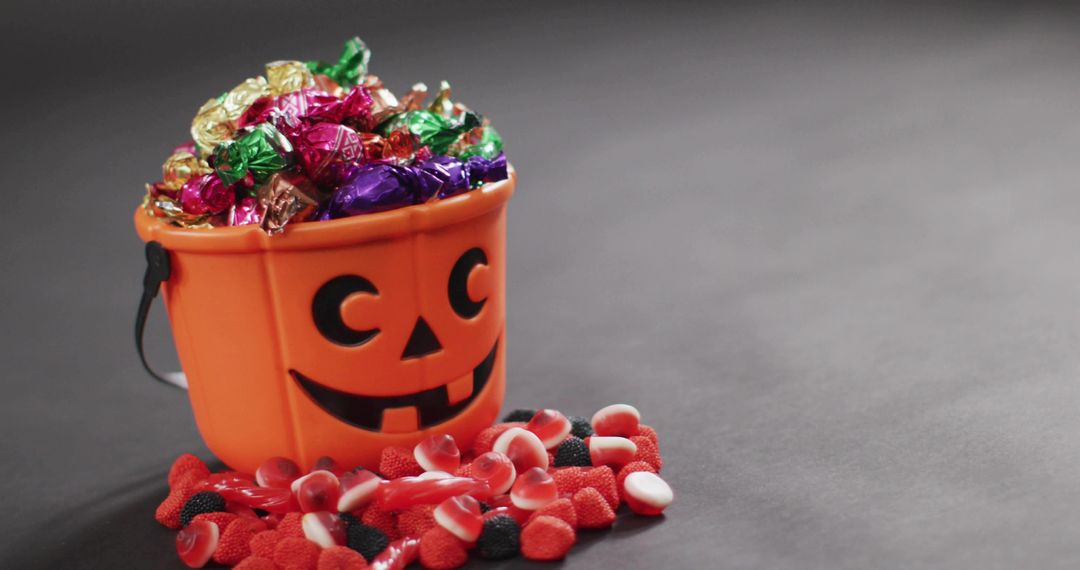 Halloween Jack O'Lantern Candy Bucket Overflowing with Wrapped Chocolates and Gummies