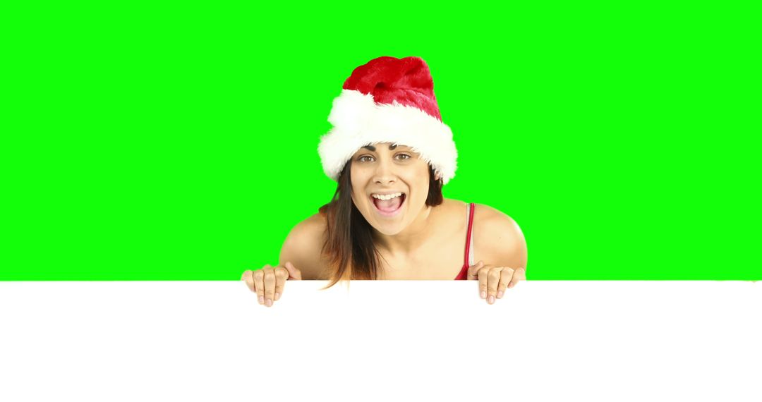 Woman in Santa Hat Peeking Over Blank Sign with Green Screen Background - Free Images, Stock Photos and Pictures on Pikwizard.com