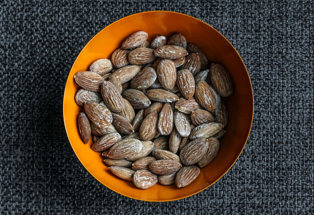 Salted Almonds in Orange Bowl on Dark Background - Free Images, Stock Photos and Pictures on Pikwizard.com