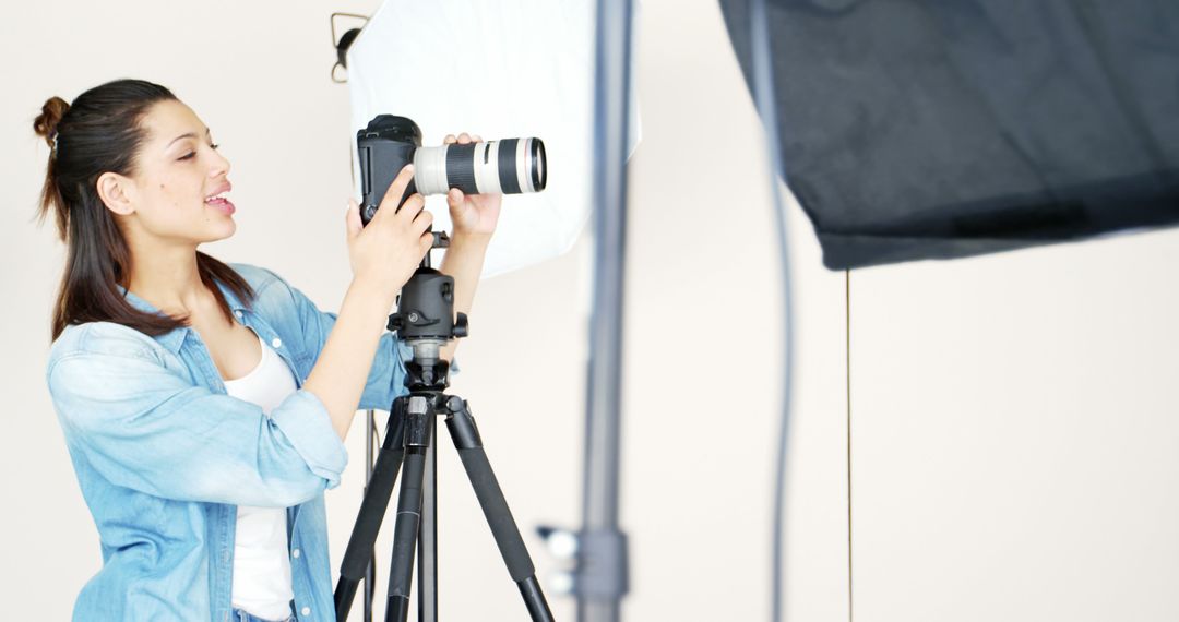 Female Photographer Adjusting Camera in Studio Setting - Free Images, Stock Photos and Pictures on Pikwizard.com