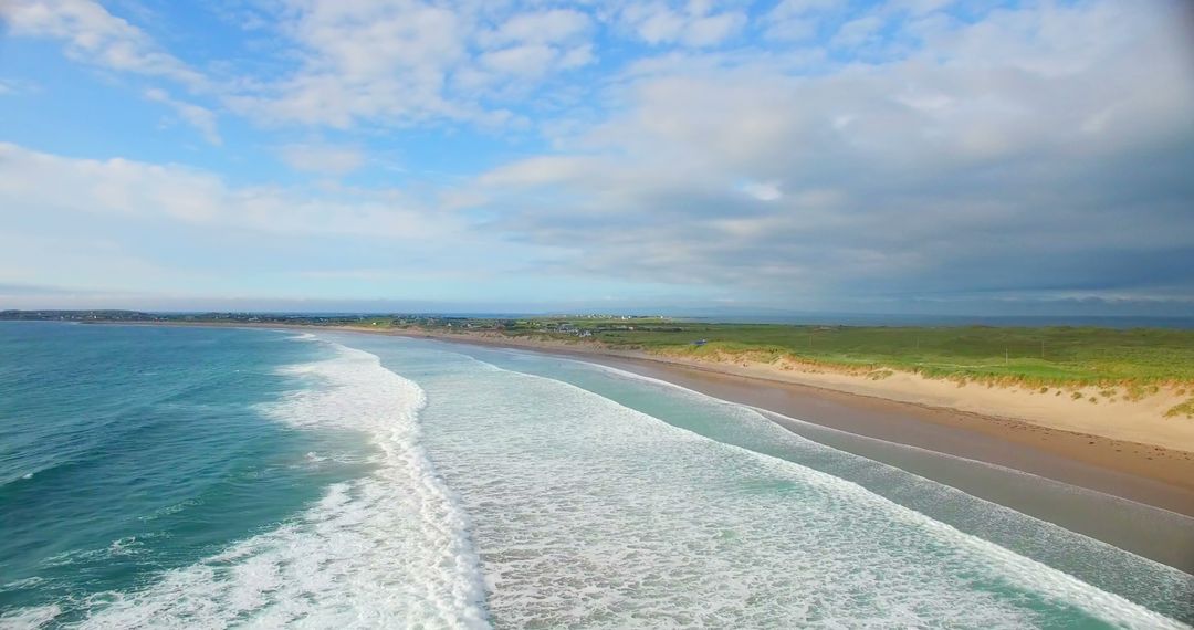 Aerial View of Peaceful Sandy Beach with Gentle Waves and Green Dunes - Free Images, Stock Photos and Pictures on Pikwizard.com