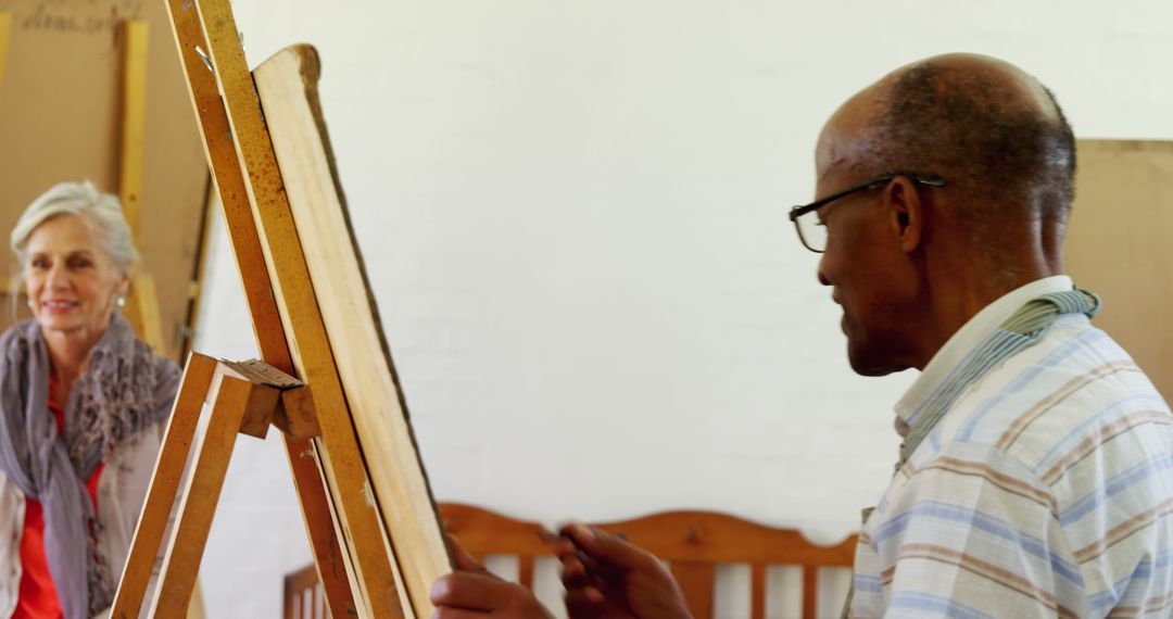 Elderly Man Painting on Easel While Woman Observing - Free Images, Stock Photos and Pictures on Pikwizard.com