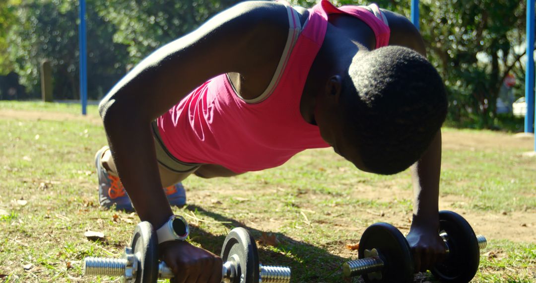 Afro-American Woman Exercising Outdoors with Dumbbells in Park - Free Images, Stock Photos and Pictures on Pikwizard.com