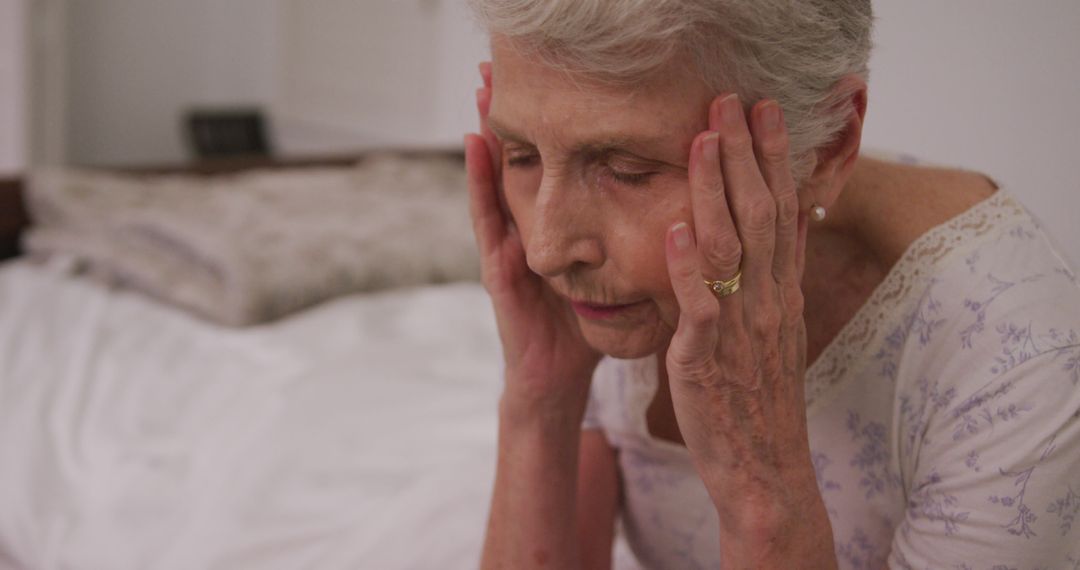 Senior Woman Sitting on Bed with Head in Hands - Free Images, Stock Photos and Pictures on Pikwizard.com