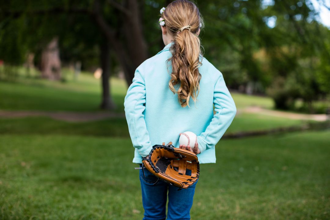 Child Holding Baseball Mitt and Ball in Scenic Park Setting