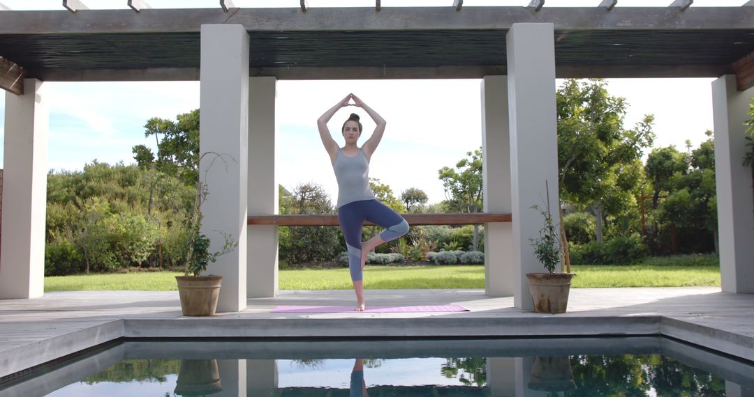 Woman Practicing Yoga Poses by Outdoor Pool on Sunny Day - Free Images, Stock Photos and Pictures on Pikwizard.com