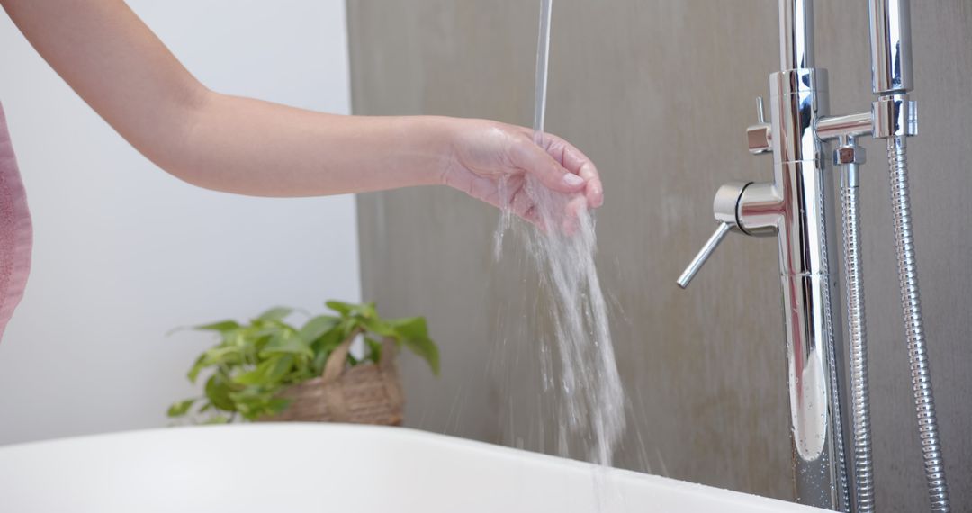 Hand Testing Water Temperature from Luxurious Chrome Faucet