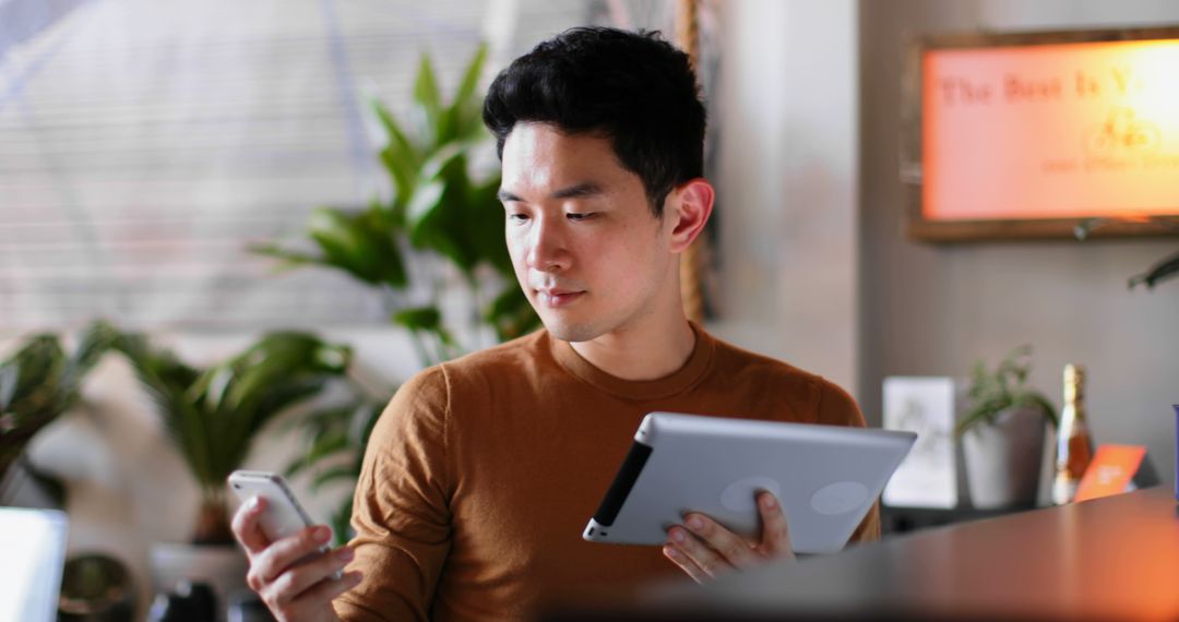 Tech-Savvy Professional Multitasking with Tablet and Smartphone