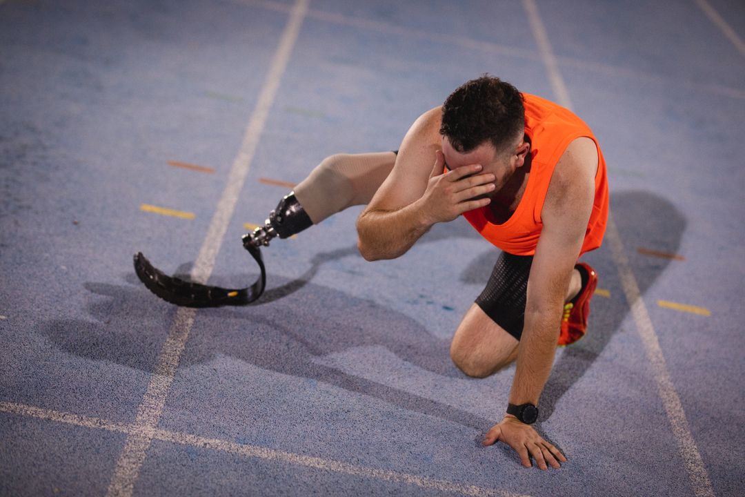 Exhausted Disabled Athlete with Prosthetic Leg Resting on Track - Free Images, Stock Photos and Pictures on Pikwizard.com