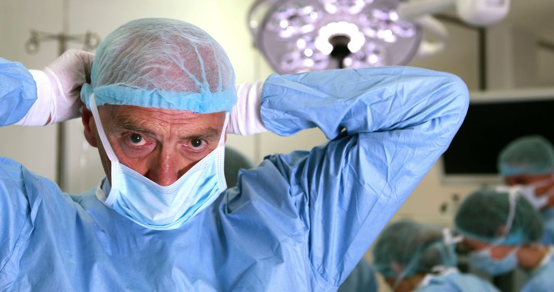 Serious Senior Caucasian Doctor Removing Mask in Operating Room - Free Images, Stock Photos and Pictures on Pikwizard.com