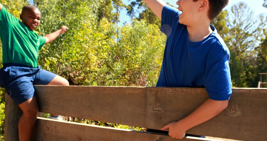 Two Kids Climbing Wooden Fence Outdoors on Sunny Day - Free Images, Stock Photos and Pictures on Pikwizard.com