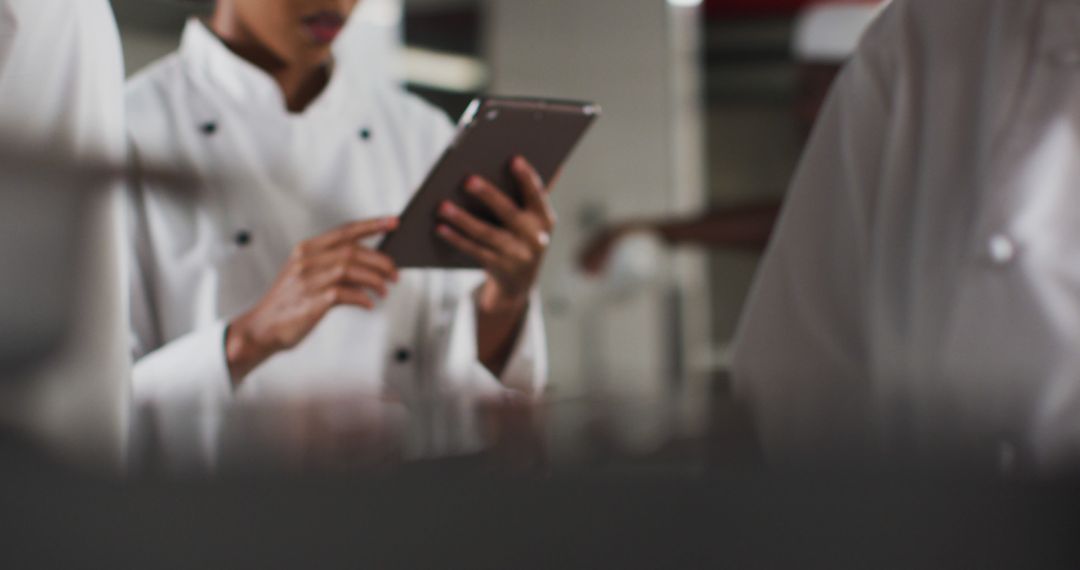 Chef Using Tablet for Efficiency in Busy Kitchen