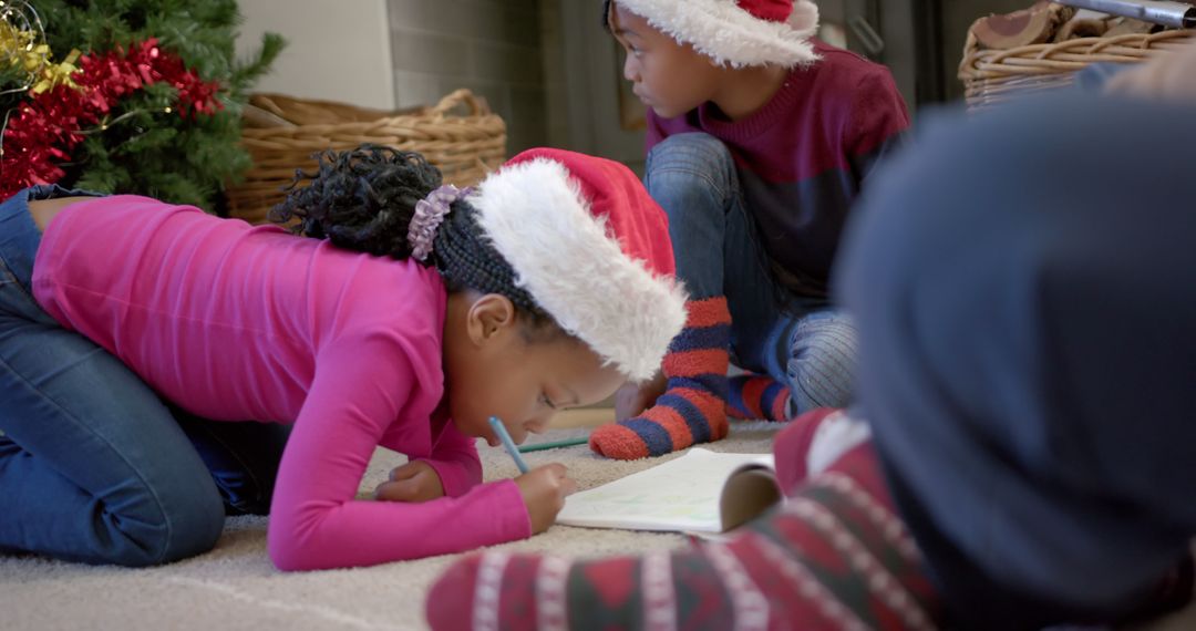 Children Drawing Together at Christmas Time with Santa Hats - Free Images, Stock Photos and Pictures on Pikwizard.com