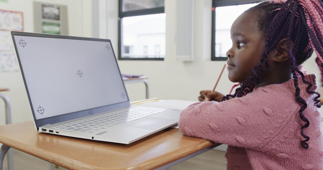 Young Student Focused on Laptop Study in Classroom Setting