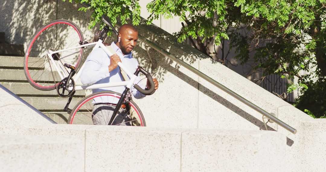 Man Carrying Bicycle Down Urban Stairs in Daylight