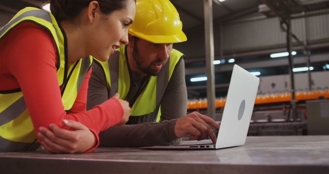 Workers in Safety Gear Using Laptop in Industrial Setting - Free Images, Stock Photos and Pictures on Pikwizard.com