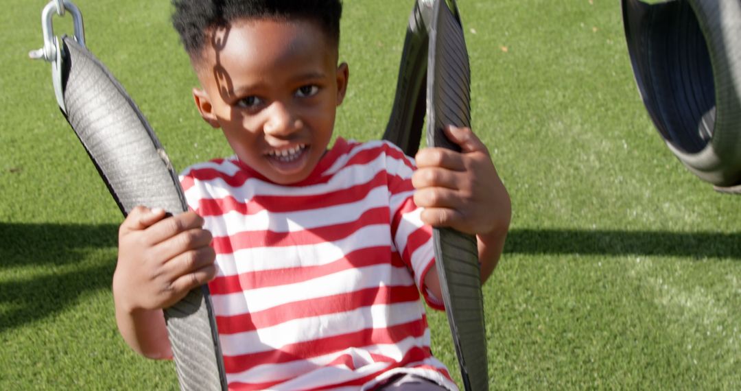 Joyful Child Enjoying Swing in Sunlit Playground