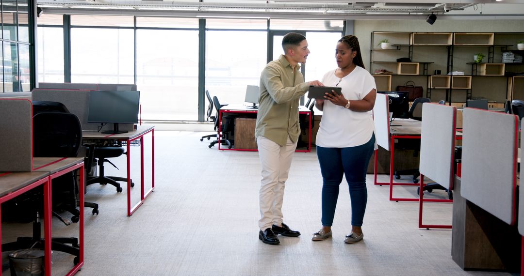 Colleagues Collaborating with Tablet in Open-Plan Office Environment