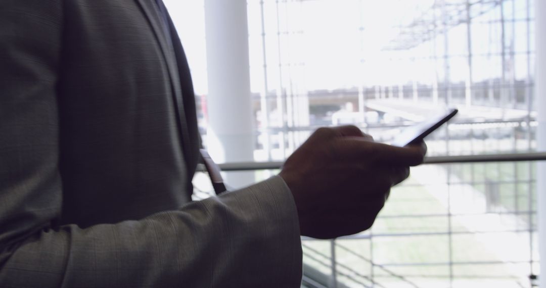 Businessman Using Smartphone in Modern Office Lobby