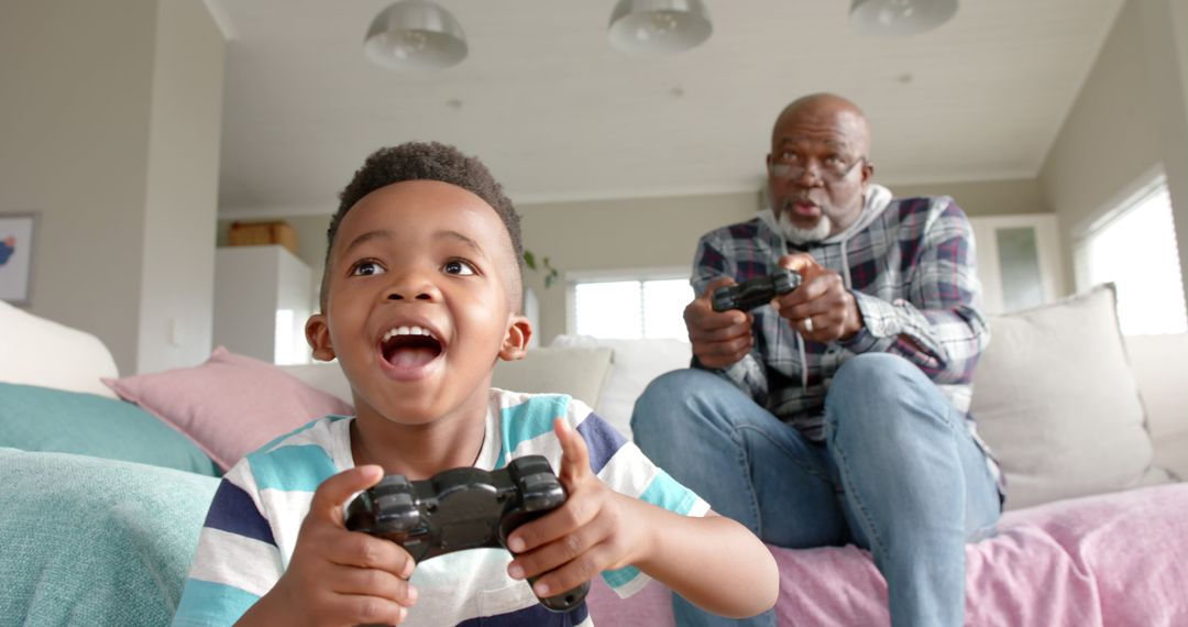 Grandfather and Grandson Playing Video Games with Joyful Expressions - Free Images, Stock Photos and Pictures on Pikwizard.com