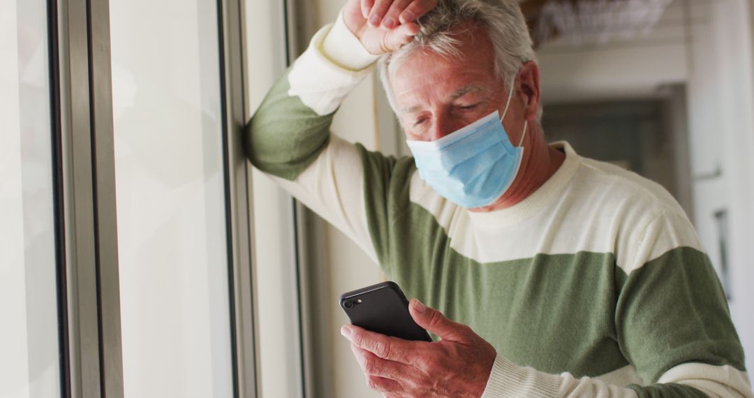 Senior Man Wearing Mask Looking Stressed Checking Smartphone - Free Images, Stock Photos and Pictures on Pikwizard.com