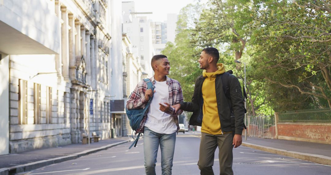 Two Friends Walking in City Street with Backpacks