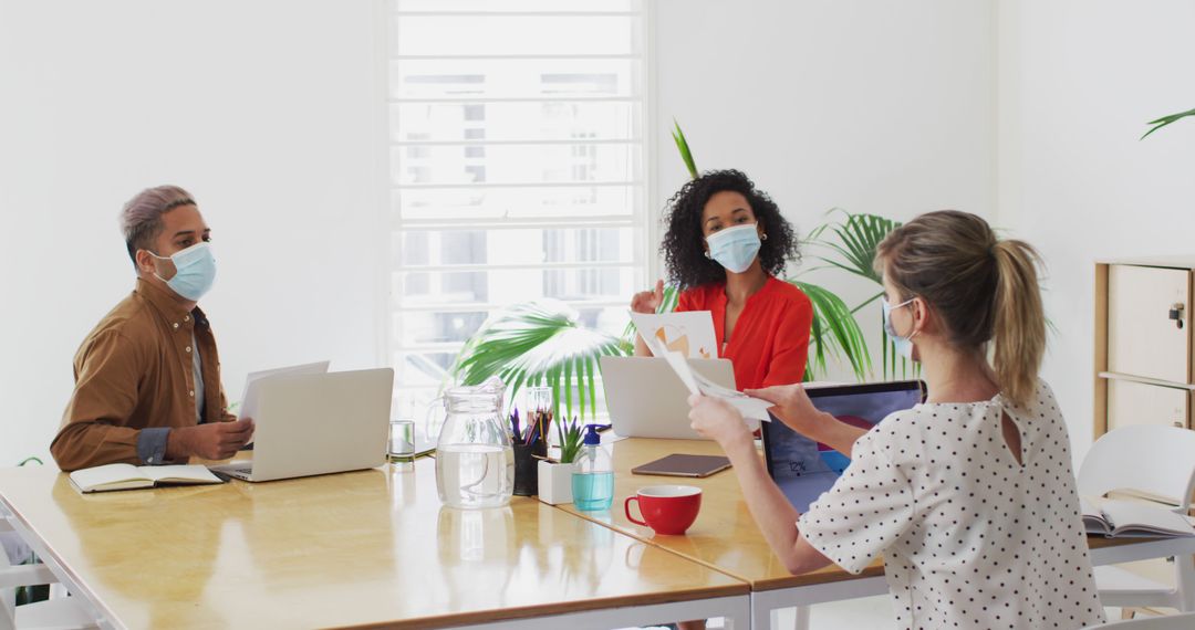 Diverse Colleagues in Masks Collaborating in Modern Office