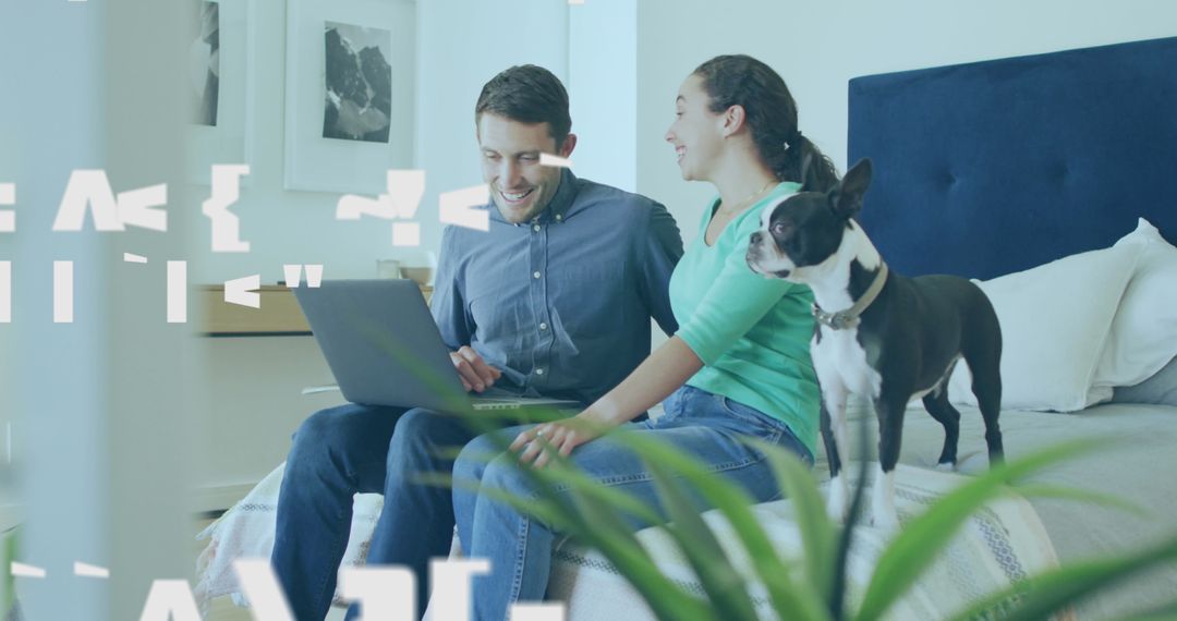 Happy Couple Using Laptop with Pet Dog on Bed