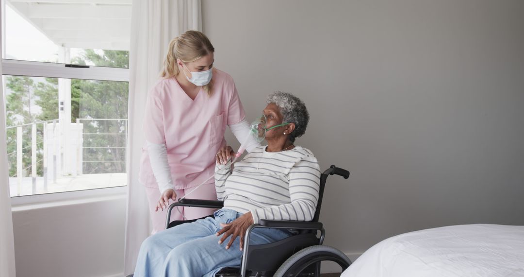 Nurse Taking Care of Elderly Patient in Wheelchair in Hospital Room - Free Images, Stock Photos and Pictures on Pikwizard.com