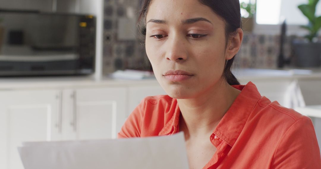 Woman Concentrating on Document While Working from Home - Free Images, Stock Photos and Pictures on Pikwizard.com